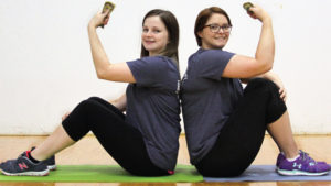 Ladies holding money on yoga mats